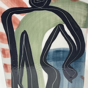 May include: A ceramic vase featuring a hand-painted abstract figure outlined in black. The design includes a central black figure with a simple face, set against a background of brushstrokes in muted terracotta, sage green, and soft blue tones.