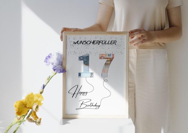 May include: A white framed print with the text "Wunscherschfuller" and the number "17" made of money bills. The text "Happy Birthday" is written below the number.