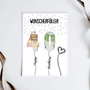 May include: A white card with black polka dots and the text "Wunschersch&uuml;ller" in black. The numbers 40 are made of euro bills and are shaped like balloons. The text "Happy Birthday" is written below the balloons.