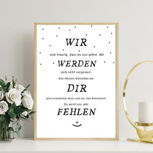 May include: A framed print with a light wood frame. The white background features black text in a simple font. The text reads "WIR WERDEN DIR FEHLEN" in German, with additional phrases. Black dots are scattered around the text.