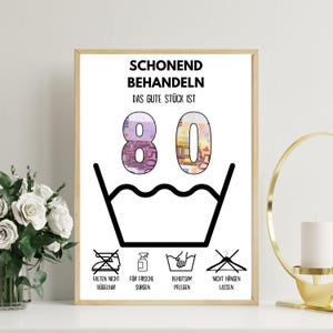 Op de afbeelding: Een witte poster met zwarte tekst die "Schonend Behandeln Das Gute St&uuml;ck Ist 80" luidt, met een zwart-wit wasinstructiesymbool. Het getal 80 is gemaakt van eurobiljetten. Onder het symbool bevinden zich vier andere zwart-wit symbolen met de tekst "Falten Nicht B&uuml;gelbar", "F&uuml;r Frische Sorgen", "Behutsam Pflegen" en "Nicht H&auml;ngen Lassen".