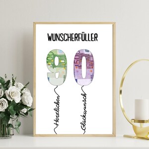 May include: A framed print with the text "WUNSCHERF&Uuml;LLER" at the top. The number "90" is formed by the image of Euro banknotes. The words "Herzlichen" and "Gl&uuml;ckwunsch" are written below the numbers. The frame is a light brown color.