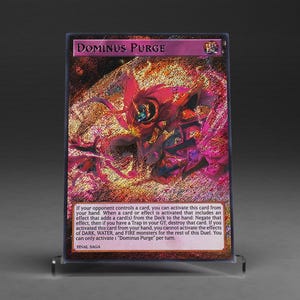 Könnte beinhalten: Eine holografische Sammelkarte mit dem Titel "Dominus Purge" und einer lebendigen, feurigen Illustration. Die Karte zeigt ein Monsterdesign in Rot- und Lilatönen. Text beschreibt die Effekte der Karte. Die Karte wird in einem transparenten Halter präsentiert.