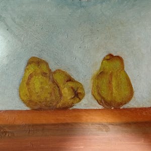 May include: An oil painting showing three yellow pears on a brown surface against a light blue and white background. The pears are painted with visible brushstrokes, a still life composition.