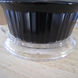 Puede incluir: Una cafetera de vidrio negro con una base de vidrio transparente y un asa. La cafetera est&aacute; llena de caf&eacute;.