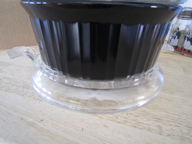 Puede incluir: Una cafetera de vidrio negro con una base de vidrio transparente y un asa. La cafetera est&aacute; llena de caf&eacute;.