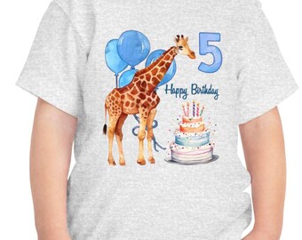 Op de afbeelding: Een lichtgrijs t-shirt met een aquarelillustratie van een giraf die naast een verjaardagstaart met drie lagen, brandende kaarsjes, blauwe ballonnen, het cijfer 5 en de tekst Happy Birthday in een blauw handschrift staat afgebeeld.