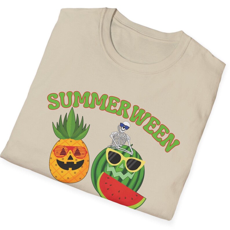May include: Beige t-shirt with a graphic design featuring a pineapple and watermelon wearing sunglasses, and a skeleton. The text "SUMMERWEEN" is arched above the graphics in green.