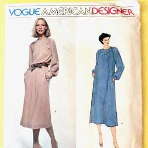 May include: Vogue American Designer sewing pattern featuring two dress designs. One dress is a long-sleeved, midi-length dress with a belt. The other is a long-sleeved, maxi-length dress. The pattern is by Jerry Silverman, pattern number 2073.