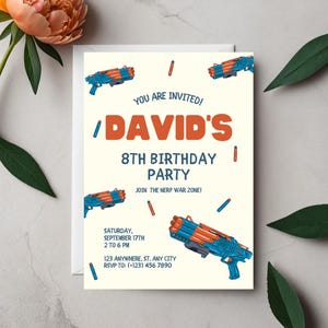 May include: A cream-colored invitation with the text "YOU ARE INVITED! DAVID'S 8TH BIRTHDAY PARTY" in orange and blue. The invitation includes the date, time, and RSVP information. Blue and orange toy guns are scattered across the invitation.