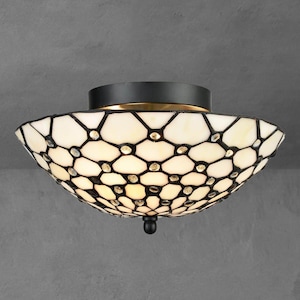May include: A decorative ceiling light fixture with a white and black geometric pattern. The light has a black base and a gold-colored trim. The shade is made of glass and features small, clear embellishments.