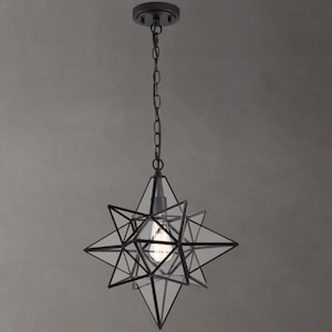 May include: Black metal star-shaped pendant light with a clear glass shade. The light is hanging from a chain.