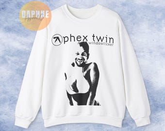 May include: White long-sleeve sweatshirt with a black graphic of a person and the text "Aphex Twin" and "Windowlicker".