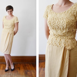 Puede incluir: Un vestido de encaje amarillo con falda de envoltura. El vestido tiene un corpi&ntilde;o ajustado y una falda fluida. El encaje es delicado e intrincado.