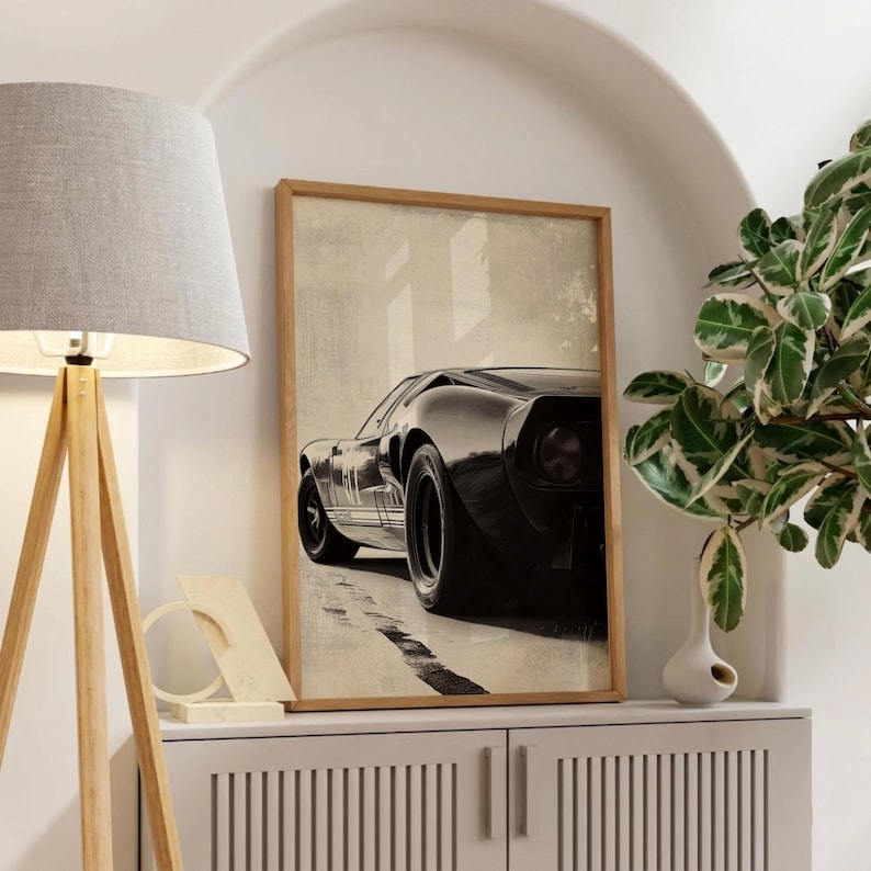 Peut inclure: Impression encadr&eacute;e d'une voiture de sport noire vintage, vue d'en bas, avec une bande blanche sur le c&ocirc;t&eacute;. L'&oelig;uvre est plac&eacute;e sur un fond neutre, cr&eacute;ant une &oelig;uvre d'art automobile classique.