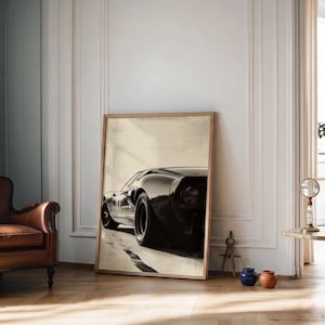 Peut inclure: Une impression encadr&eacute;e d'une voiture de sport noire vintage, vue de l'arri&egrave;re, l&eacute;g&egrave;rement de c&ocirc;t&eacute;. La voiture est plac&eacute;e sur un fond neutre avec une route de couleur claire. L'impression est dans un cadre en bois et est appuy&eacute;e contre un mur.