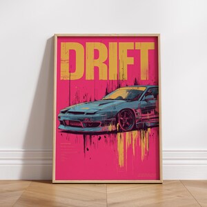 May include: A rectangular wall art print featuring a stylised blue sports car on a vibrant pink background. The word DRIFT is printed in large yellow letters at the top. The design includes yellow and black paint drip effects below the car.