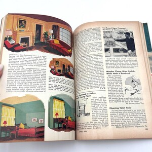 May include: Open book with illustrations of interior design, including rooms with fireplaces, furniture, and color schemes. The pages also feature text on home improvement topics and DIY projects.