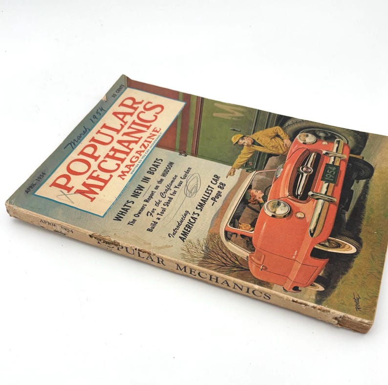 May include: Vintage March 1954 issue of Popular Mechanics magazine. The cover features an illustration of a red car with the text "America's Smallest Car." The magazine's title is in large red letters, with the issue date and price visible.