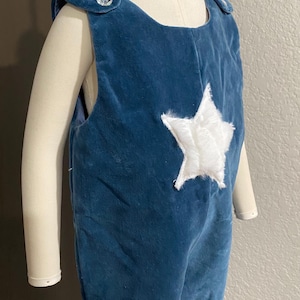 Winter blue velvet featuring a white fuzzy star, and crystal ice buttons. A combo one piece to wear while playing with new toys. One of kind