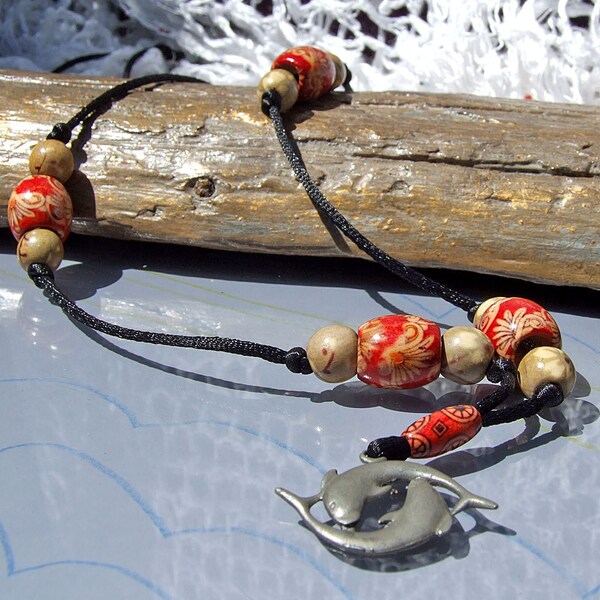 Beige, cream and red  flower patterned wood bead necklace on black cord with dolphin pendant, long necklace.
