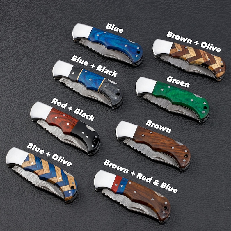 Collection of handcrafted Damascus steel folding knives with various custom wood handle designs including 
blue, green, chevron, and mixed wood patterns. Compact and durable pocket knives ideal for personalized graduation gifts, 
outdoor use, or groomsmen sets.