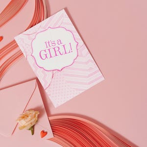 Cartão de chá de bebê para menina anunciando "É uma menina" para presentear em um chá de bebê.