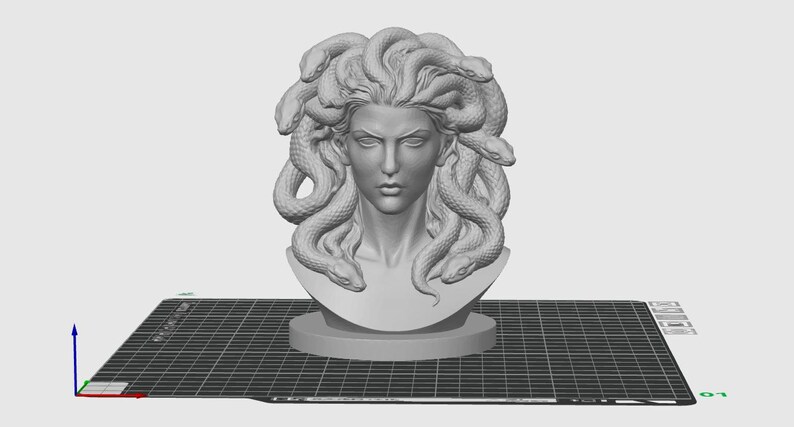 May include: A gray bust of Medusa, a figure from Greek mythology, with snakes for hair. The sculpture is on a round base and set against a grid background. The bust is a 3D model.