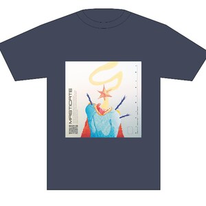May include: A navy blue t-shirt featuring a graphic print of a colourful, abstract creature with a star on its head. The text "MASTICATE" is printed vertically on the left side of the graphic.