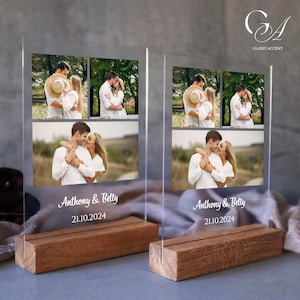 May include: Two clear acrylic photo frames with a wood base, each displaying four photos of a couple. The frames are engraved with the names "Anthony & Betty" and the date "21.10.2024".