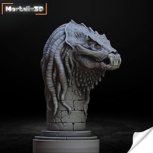 May include: A gray, 3D-printed sculpture of a creature's head with a detailed, textured design. The sculpture features a reptilian face with sharp teeth, large eyes, and tentacle-like appendages. The sculpture is mounted on a stone pillar.