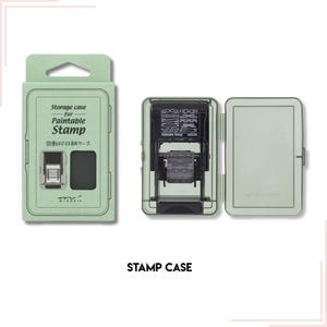 Pode incluir: Um estojo de armazenamento verde claro para um carimbo pintável, com o texto "Storage case for Paintable Stamp" em inglês e japonês. O estojo do carimbo está aberto, revelando um carimbo preto com vários desenhos. As palavras "STAMP CASE" estão na parte inferior.