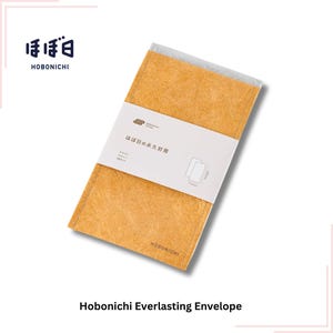 May include: An orange Hobonichi Everlasting Envelope. The envelope has a textured surface and a white band with Japanese text and a diagram. The Hobonichi logo is in the top left and bottom. The envelope is rectangular.