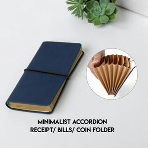 Puede incluir: Un archivador minimalista azul marino para recibos, facturas y monedas con cierre de banda elástica marrón. El archivador se muestra cerrado y abierto, revelando el interior en forma de acordeón. El texto "MINIMALIST ACCORDION RECEIPT/ BILLS/ COIN FOLDER" está impreso en la parte inferior.