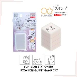 May include: A white and gray stamp set with a cat design. The set includes a stamp, ink pad, and guide. The stamp is labeled "SUN-STAR STATIONERY PYOKKORI GUIDE STAMP CAT". The stamp is designed to be used with the included guide.