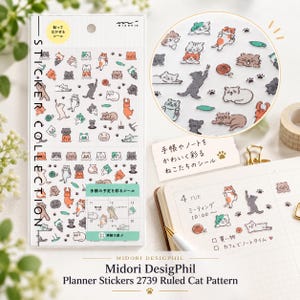 May include: A sheet of Midori DesignPhil planner stickers featuring various small, colorful cat illustrations, paw prints, and yarn balls. The clear plastic sheet includes Japanese text and is displayed alongside a notebook with stickers applied.