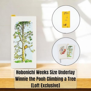 May include: A rectangular Hobonichi Weeks size underlay featuring a Winnie the Pooh illustration of the character climbing a tree. The yellow reverse side displays line art of Pooh and bees with the text Winnie the Pooh. Two planners are shown.