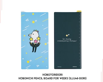 Op de afbeelding: Een blauw en zwart Hobonichi-potloodbord voor weken met een schattig cartoonfiguur aan de voorkant. De tekst "So many interesting things!" staat op de zwarte kant van het bord.