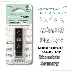 Puede incluir: Un sello de rodillo negro con tres diseños: un pájaro, montañas y un árbol. El sello está etiquetado como "Paintable Stamp" e incluye el texto "Mountain Scenery". El embalaje es verde claro y blanco.