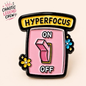 May include: A metal enamel pin shaped like a light switch with a pink background and black border. The text HYPERFOCUS is at the top, with ON and OFF labels. A pink switch is in the middle, flanked by a yellow flower on the left and a blue flower on the right.