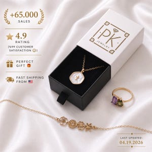 May include: A jewelry set featuring a gold necklace with a white pendant and cross, a ring with purple and green stones, and a floral bracelet. The jewelry is displayed in a white box with the "PK JEWELRY" logo. The image also shows the text "+65.000 SALES".