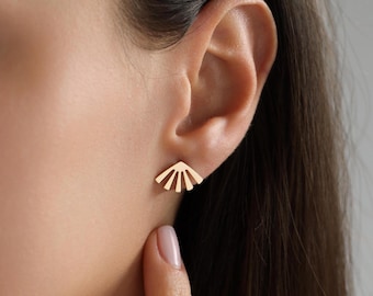 May include: Gold-toned earrings with a geometric fan-shaped design. The earrings are small and delicate, and they would be a great addition to any jewelry collection.