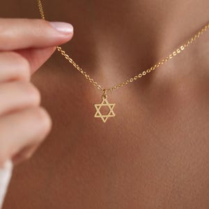 May include: A gold chain necklace with a small gold Star of David pendant.