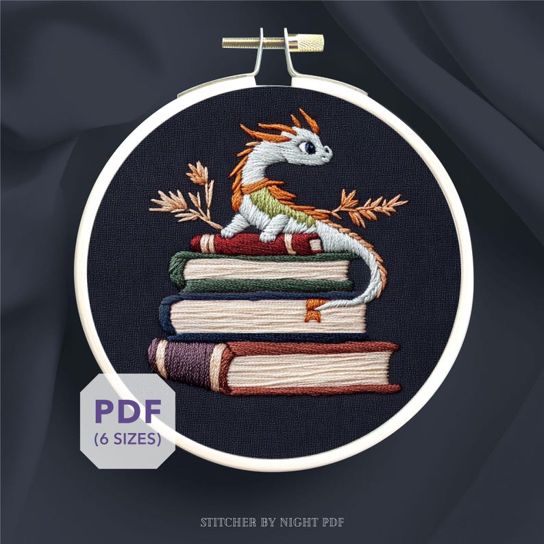 K&ouml;nnte beinhalten: Gesticktes Drachendesign in einem Stickrahmen. Der Drache ist wei&szlig;, gr&uuml;n und orange und sitzt auf einem Stapel roter, gr&uuml;ner und brauner B&uuml;cher. Der Text "PDF (6 GR&Ouml;SSEN)" befindet sich in einem wei&szlig;en Feld. Der Text "STITCHER BY NIGHT PDF" steht unten.