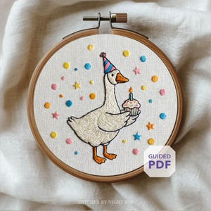May include: Embroidered hoop art featuring a goose wearing a party hat and holding a cupcake with a lit candle. The design includes colorful confetti and stars. The text "Guided PDF" is visible.