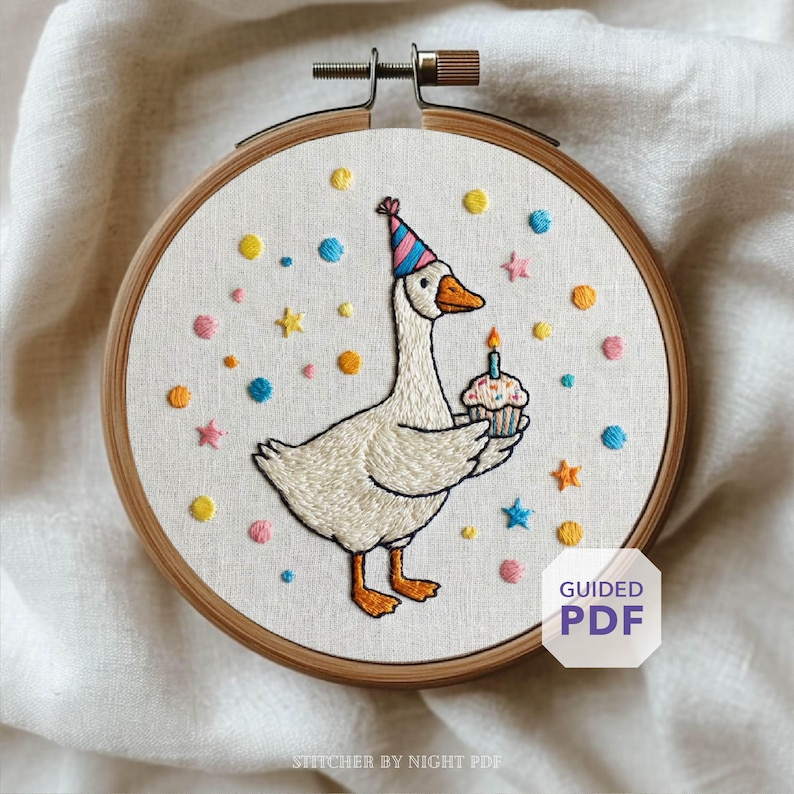 May include: Embroidered hoop art featuring a goose wearing a party hat and holding a cupcake with a lit candle. The design includes colorful confetti and stars. The text "Guided PDF" is visible.