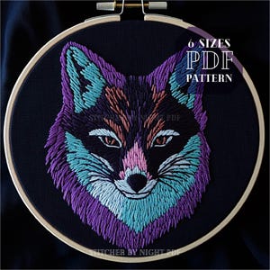 Puede incluir: Diseño de cabeza de zorro bordado en un esquema de color morado, turquesa y rosa sobre tela negra en un aro de bordado de madera. El texto "6 SIZES PDF PATTERN" está en la esquina superior derecha de la imagen.