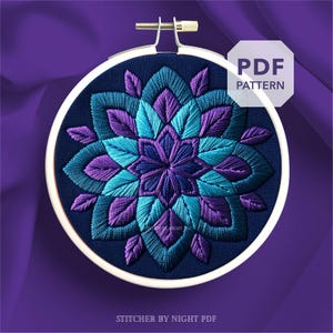 May include: A detailed embroidery design in a wooden hoop. The design features a symmetrical floral pattern in shades of teal, purple, and navy blue. The text "PDF PATTERN" is in a white hexagon. The text "STITCHER BY NIGHT PDF" is at the bottom.
