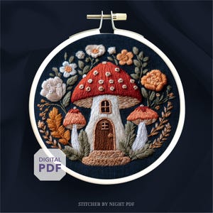May include: Embroidered mushroom house design in a round hoop. The house has a red cap with white spots, a brown door, and a small window. Surrounding the house are white, orange, and tan flowers and foliage. The text "DIGITAL PDF" is in the lower left.
