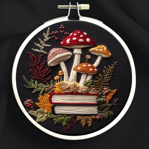 May include: Embroidered design of mushrooms and autumn leaves on a black background, set in a white embroidery hoop. The design includes the text "MUSHROOMS" and "stitch fairy tales". The design is for hand embroidery.